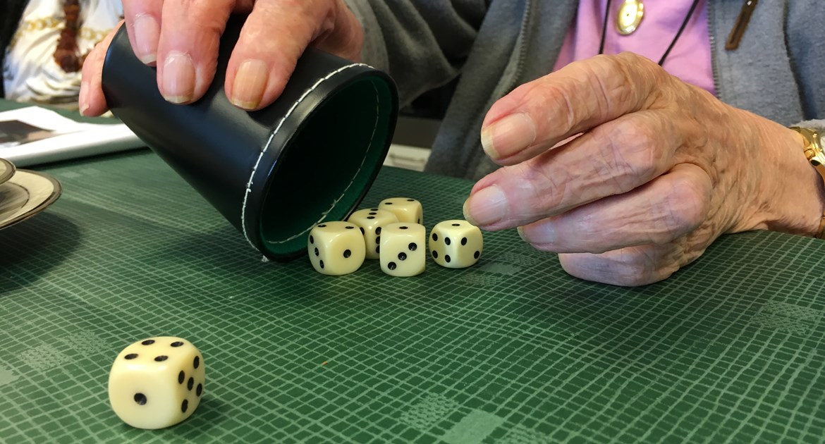 En ældre dame spiller yatzy på Plejecenter Trekroner. Hun har slået 1, 2, 3, 4 og mangler kun en femmer.