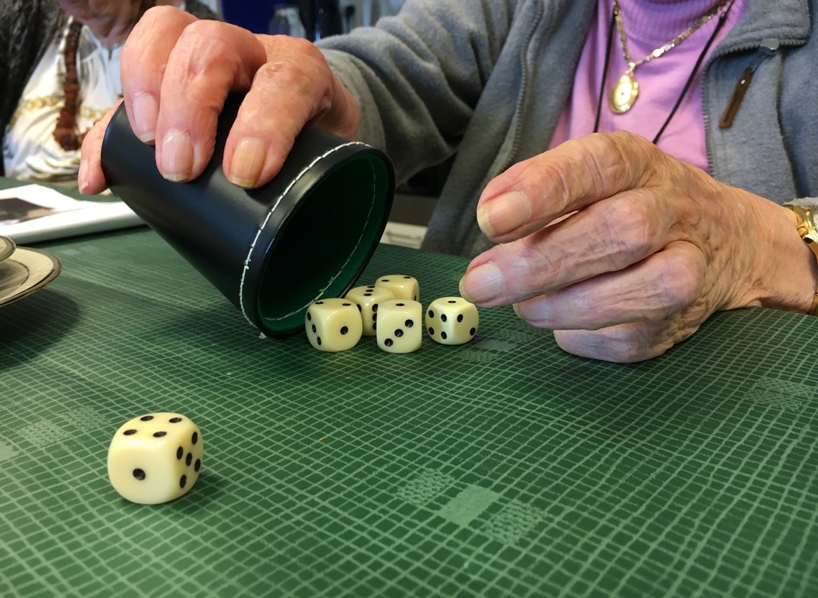 En ældre dame spiller yatzy på Plejecenter Trekroner. Hun har slået 1, 2, 3, 4 og mangler kun en femmer.